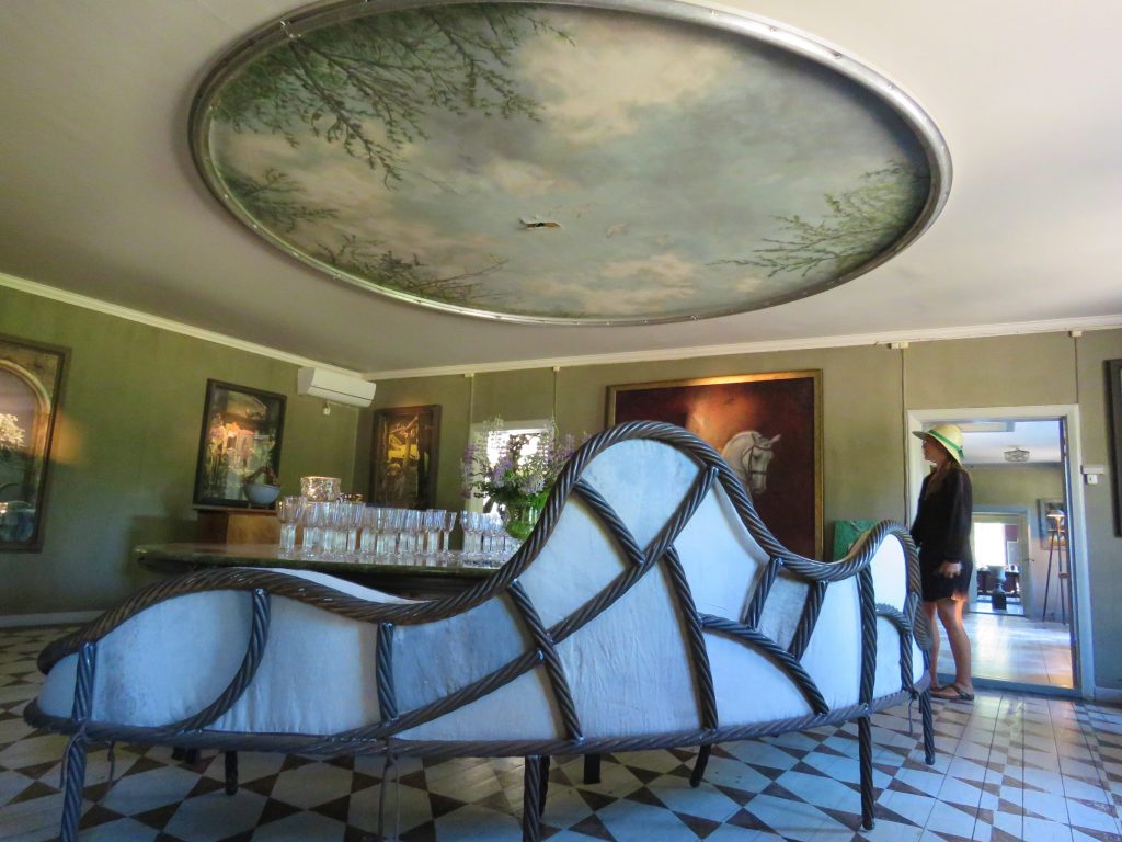Takmaleri og Tage Andersens utformede sofa i rommet med flygel. 