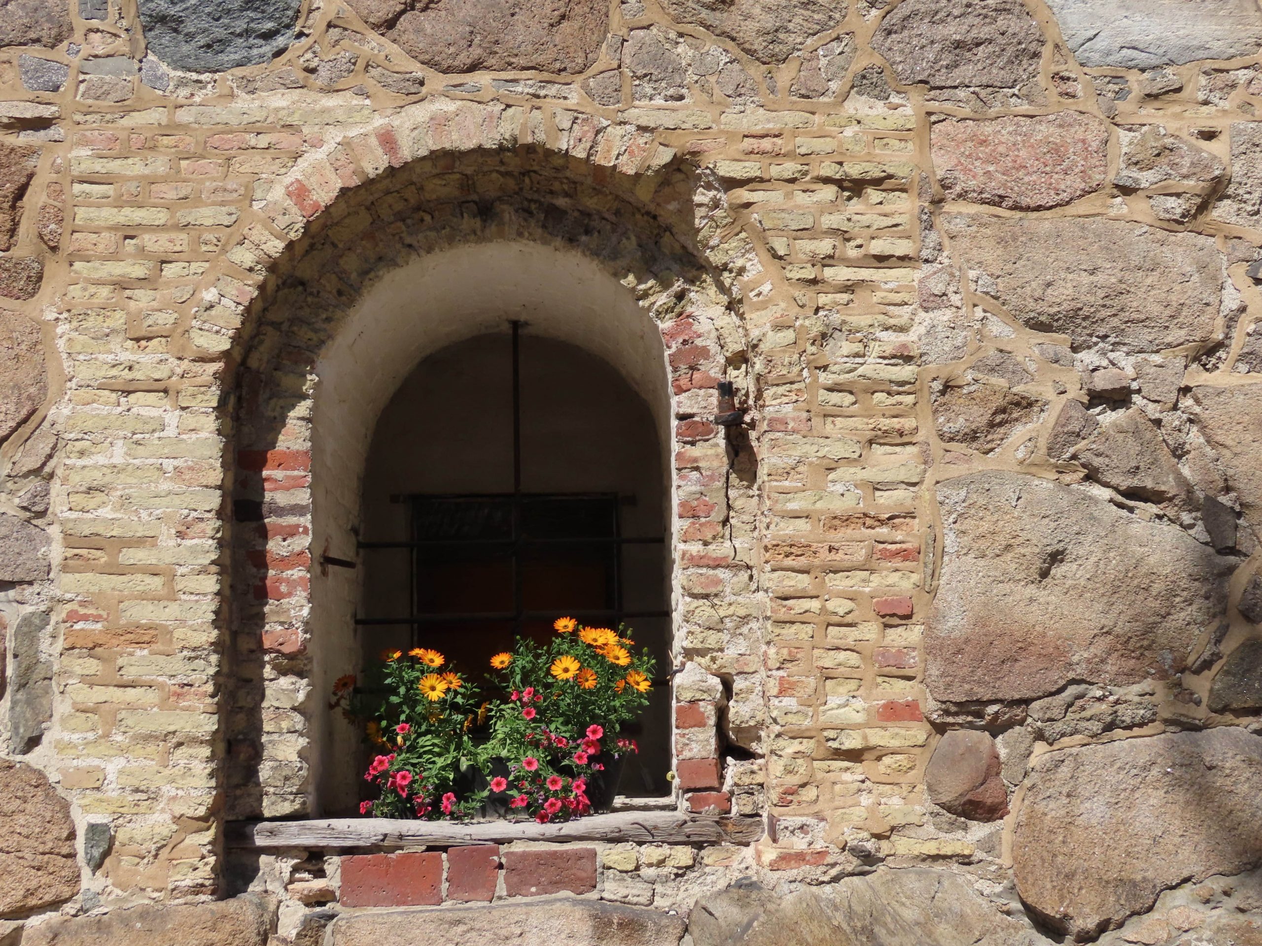 Blomster i nisjevinduer i flotte, gamle bygg