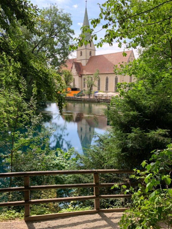 Klosterkirken som speiler seg i kilden Bautopf - Vår bobilferie gjennom Europa