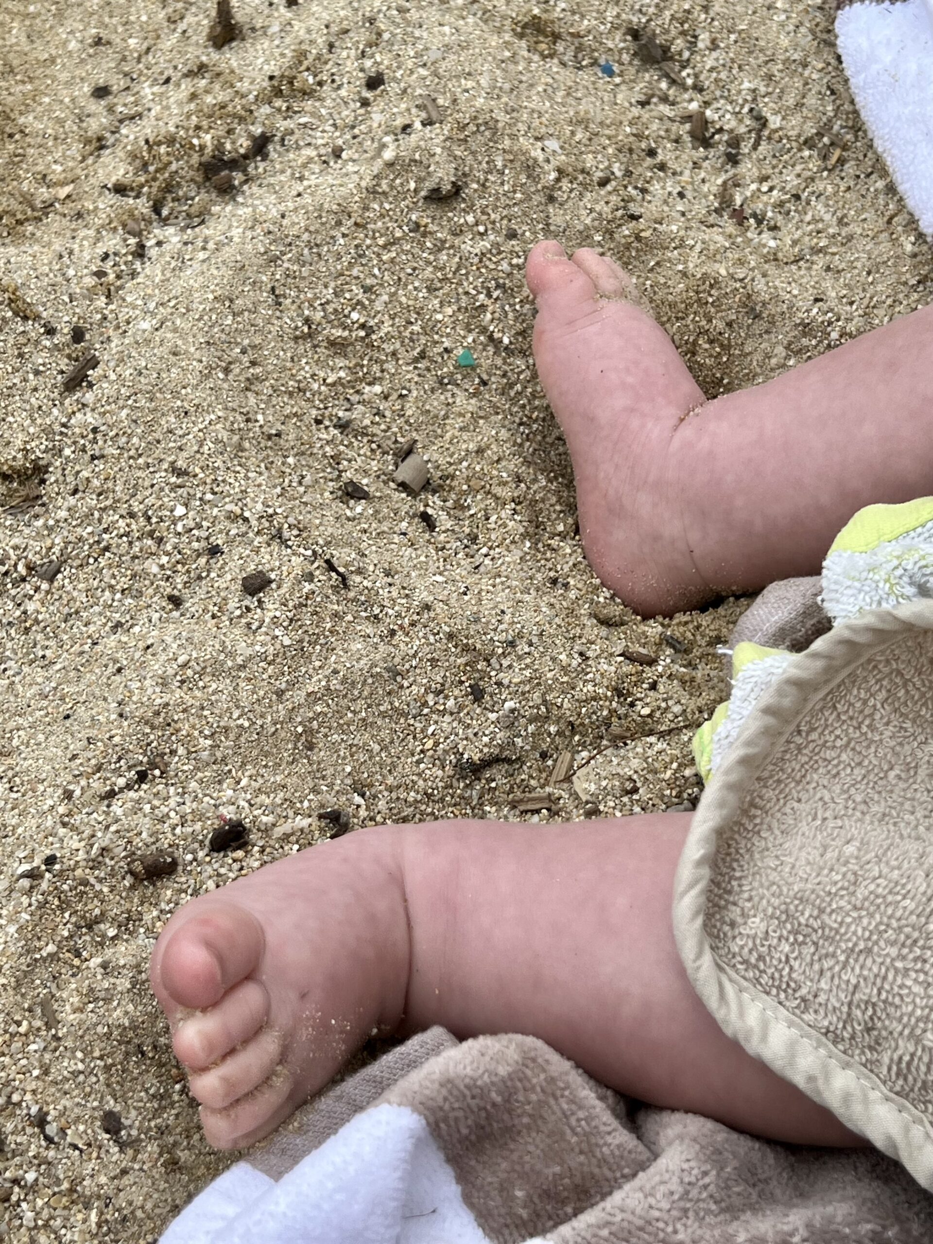Føtter som liker seg i varm sand - på stranden i Prairies de la Mer